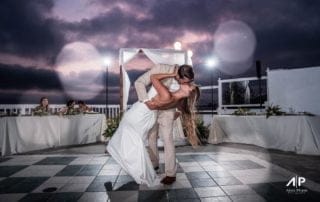 A bride and groom sharing their first dance at a picturesque Laguna Beach wedding venue during sunset.