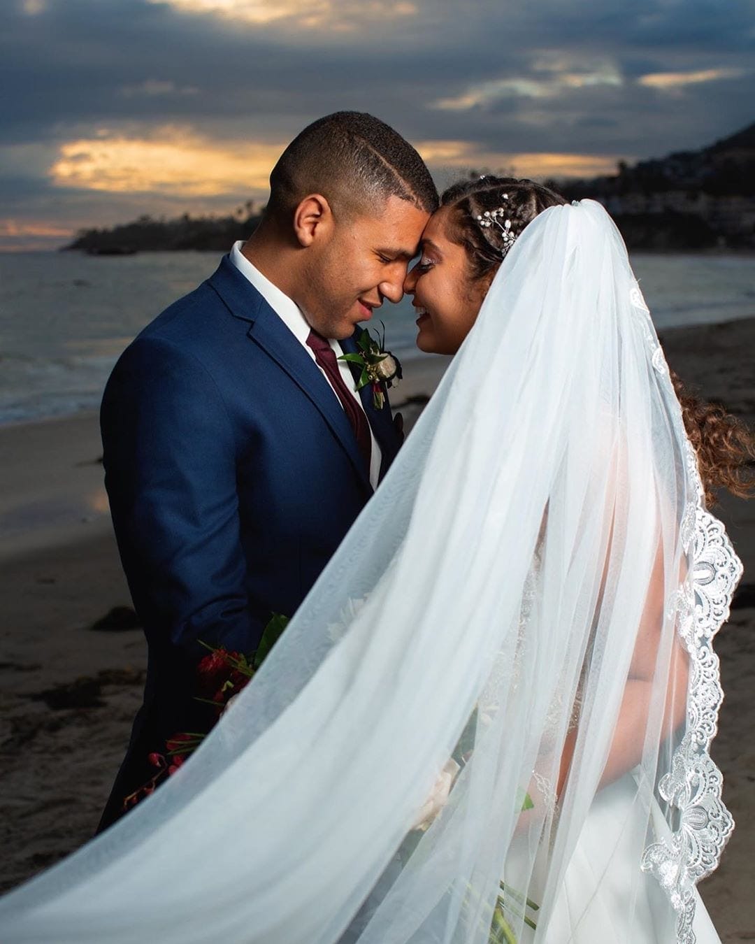 A couple celebrating their special day at a picturesque beach during sunset in Southern California.