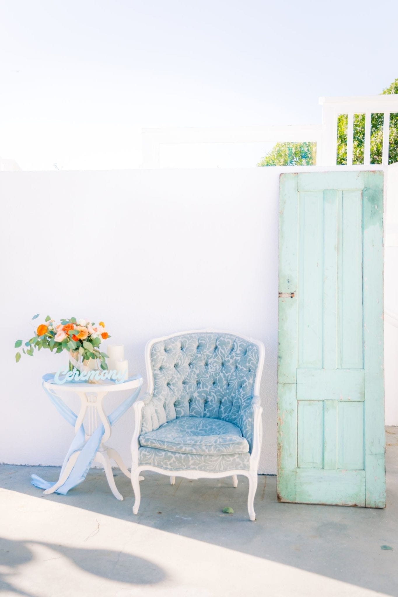A blue chair sits next to a white door in a wedding venue.