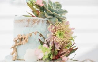 A wedding cake adorned with succulents and seashells, ideal for southern California wedding venues.