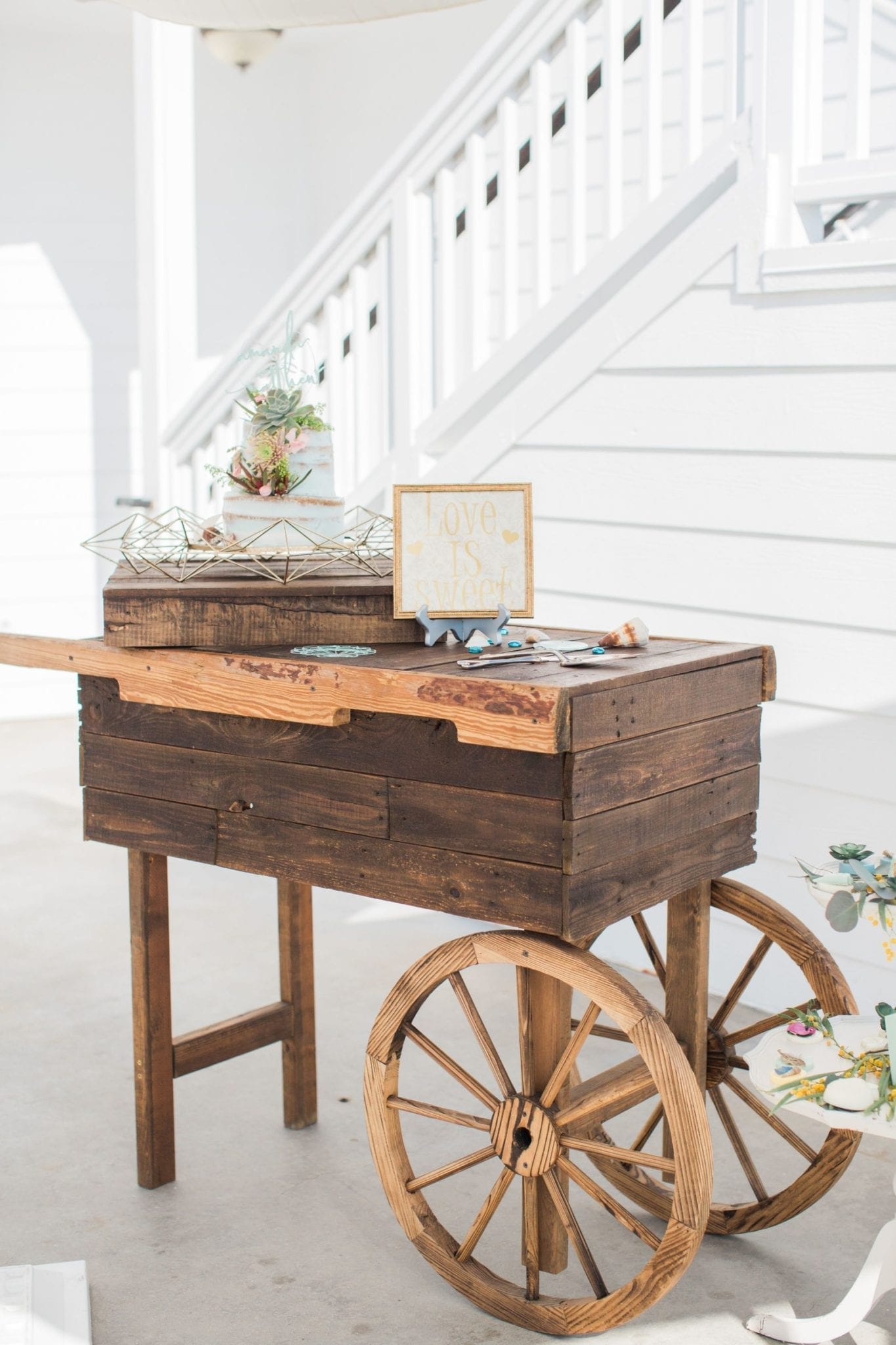 A rustic wooden cart adorned with a charming sign, ideal for weddings in Southern California.