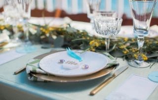 An elegant table setting with plates, silverware, and eucalyptus leaves at a Southern California wedding venue.